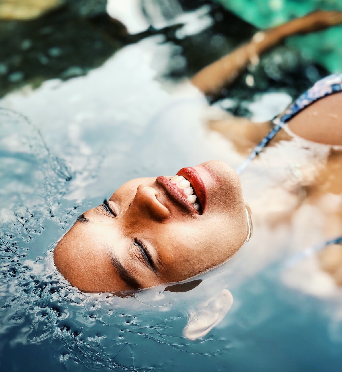 A smiling woman floating in water.